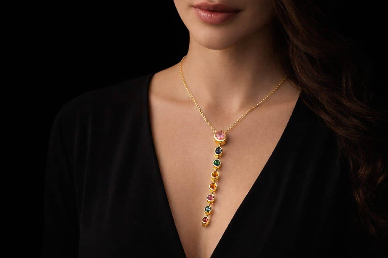 Woman wearing Zevras gold rainbow pendant necklace
