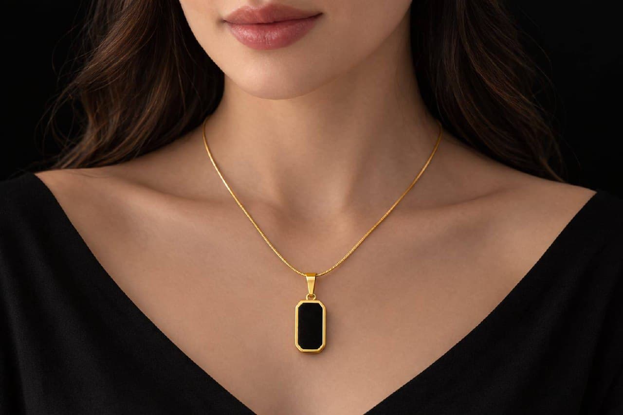Woman wearing Zevras black onyx pendant on gold chain